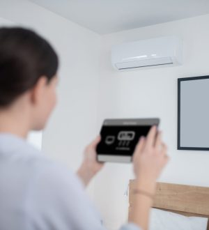 woman-turning-air-conditioner-using-tablet woman-turning-air-conditioner-using-tablet